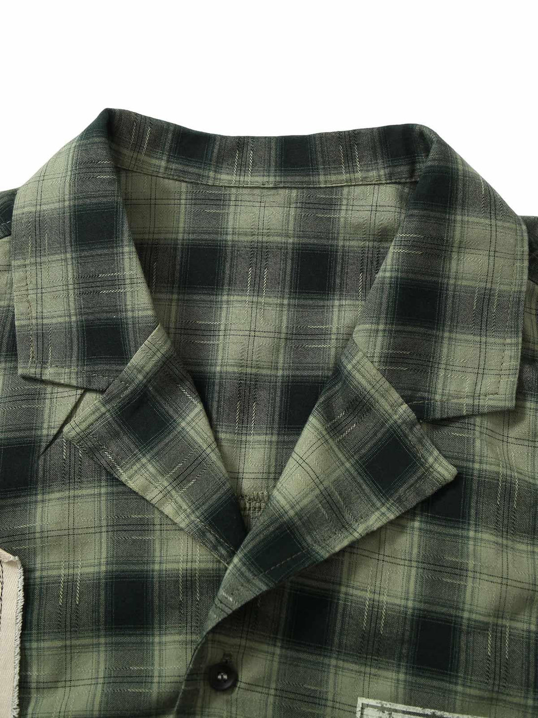 A detailed view of the plaid fabric and collar on TALISHKO's short sleeve shirt.