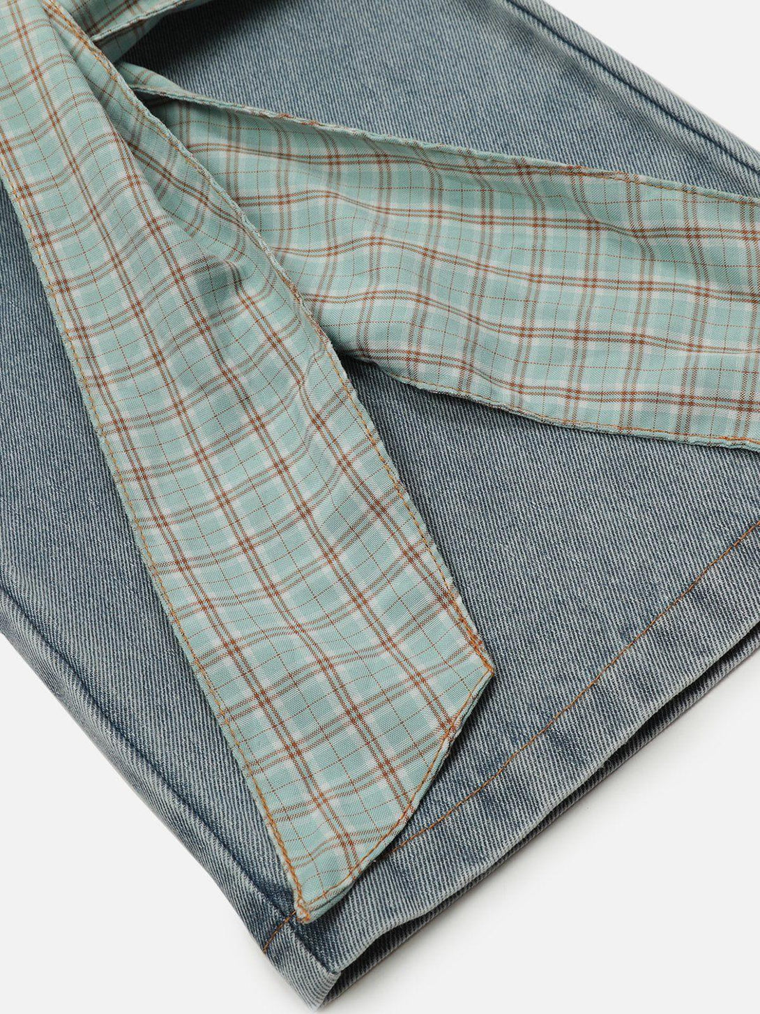 Plaid detailing and stitching on TALISHKO loose jeans, highlighting unique design elements.