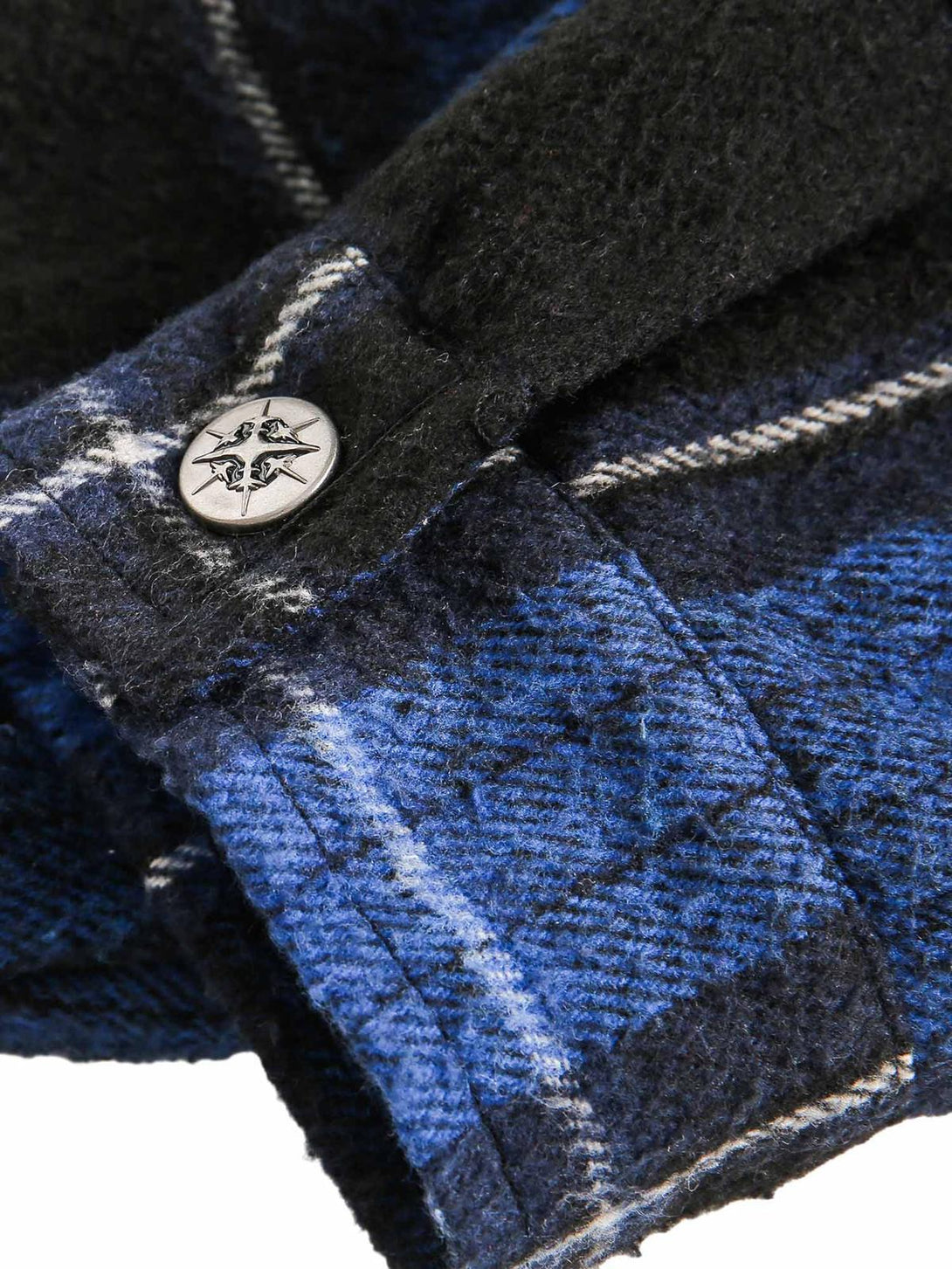 Detailed fabric and stitching on TALISHKO's blue plaid hooded shirt, highlighting the button detail.