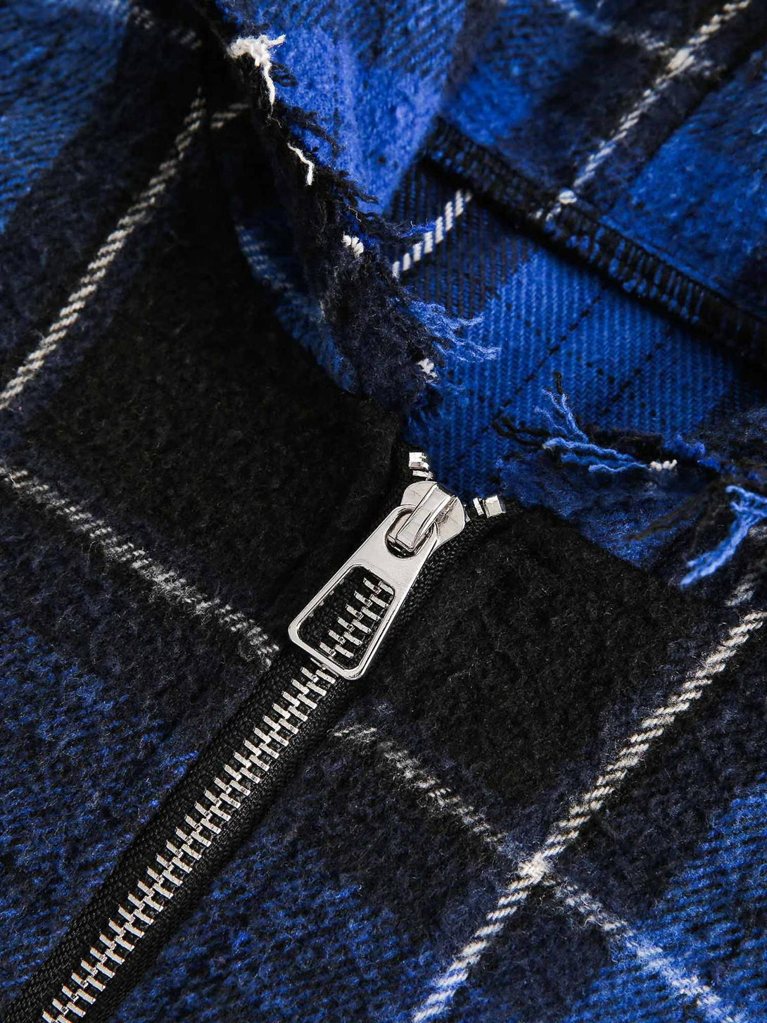Intricate look at TALISHKO's blue plaid fabric and zipper detail, showcasing texture and design.