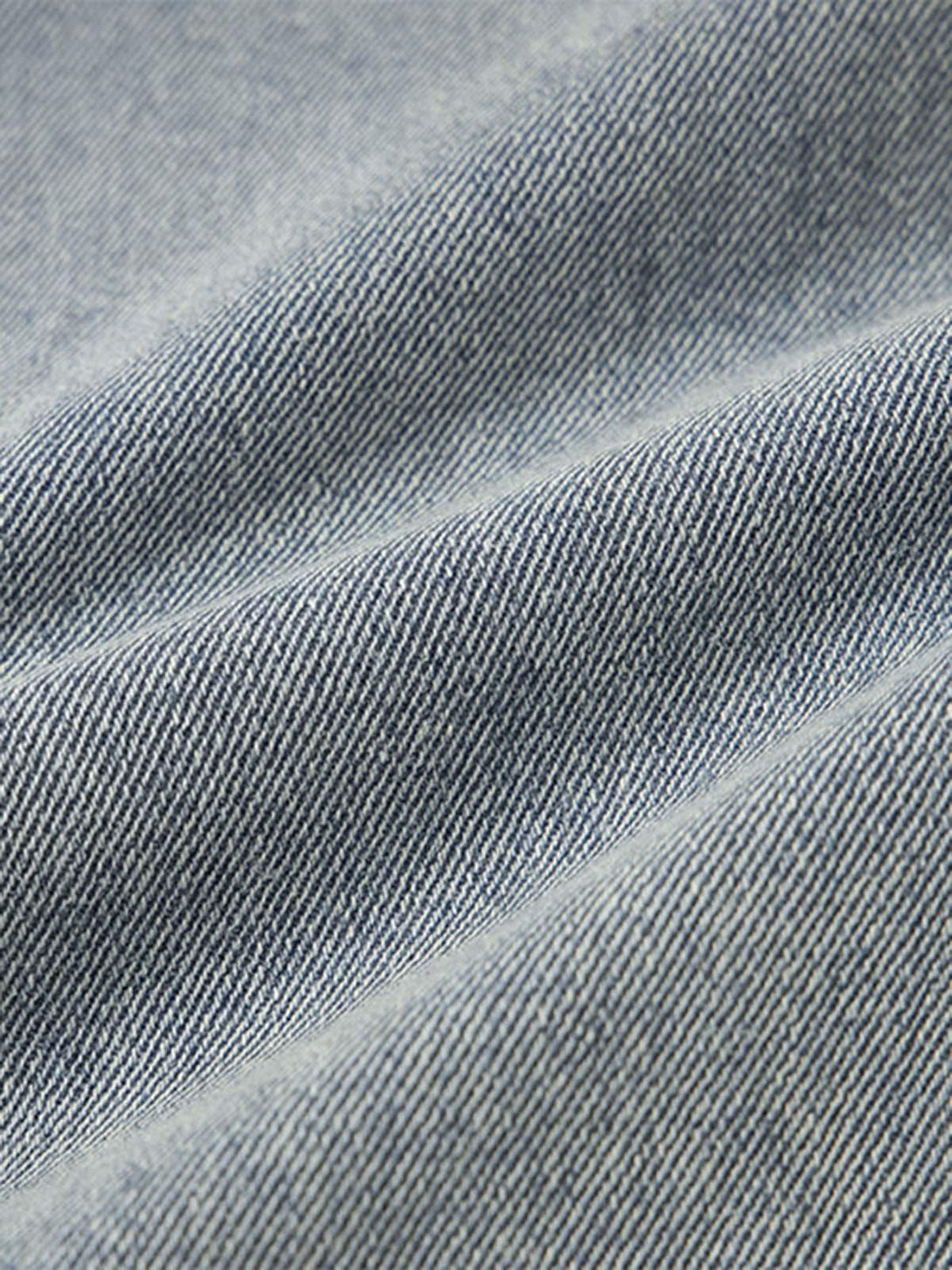 Zoomed-in texture of denim fabric on TALISHKO baggy jeans, highlighting intricate weave.