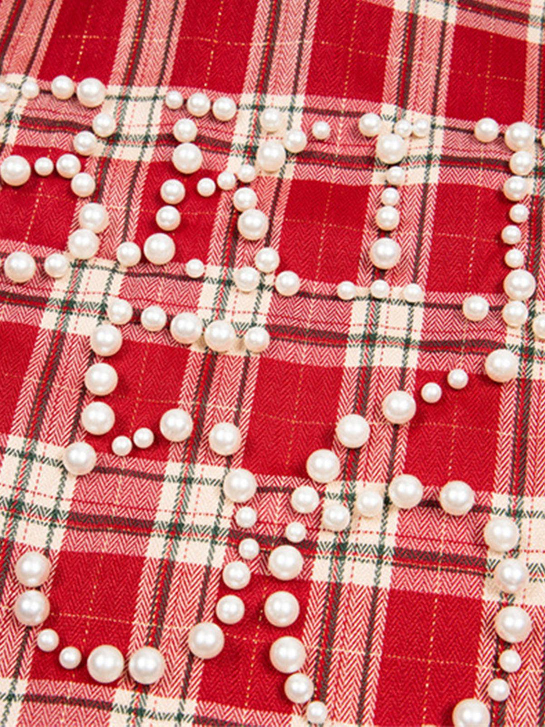 Zoomed-in view of TALISHKO's red plaid fabric adorned with pearl-embellished lettering.