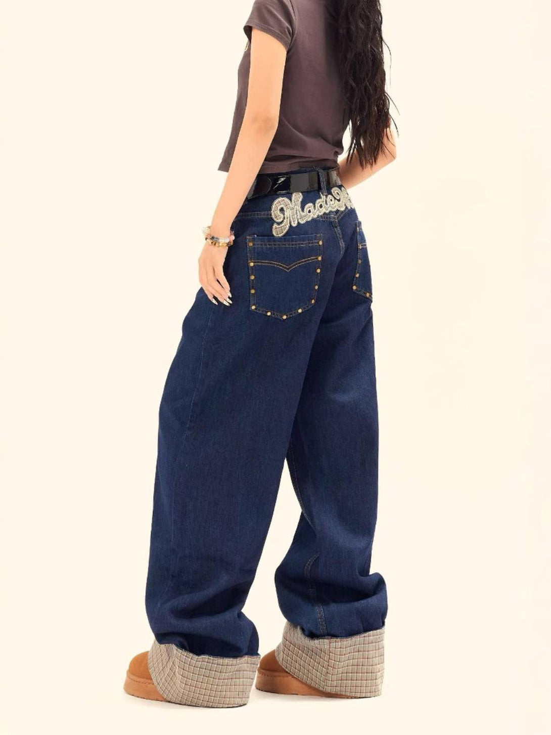 Wide-leg plaid panel jeans by TALISHKO, styled with embroidered details and folded cuffs.