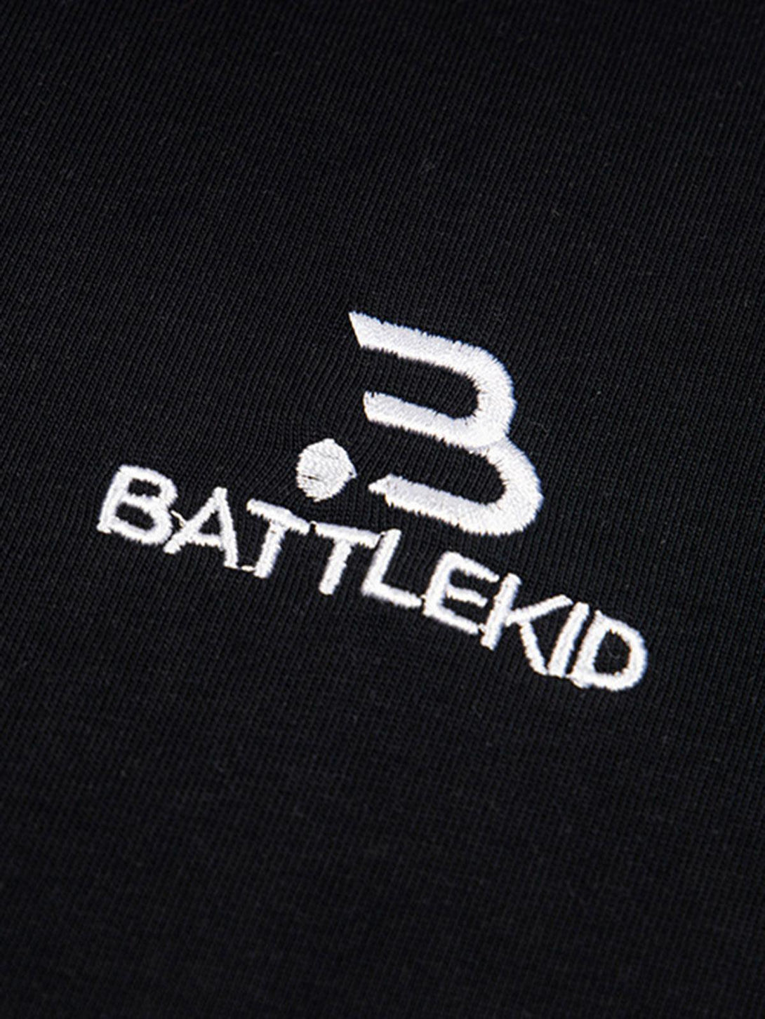 Intricate look at TALISHKO's black T-shirt, highlighting the embroidered logo detail.