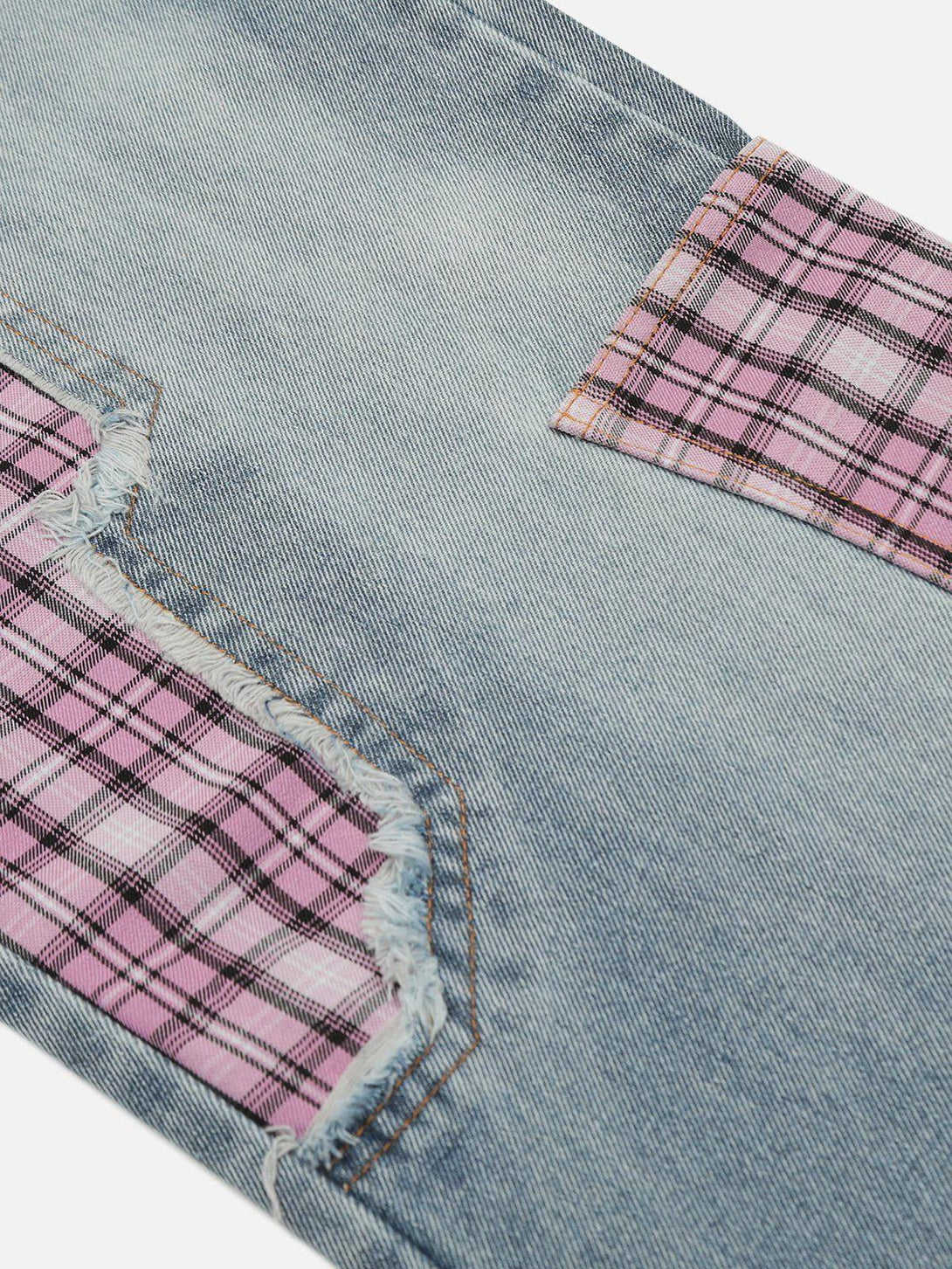 Zoomed-in texture of TALISHKO jeans showcasing pink plaid patchwork for a trendy detail.