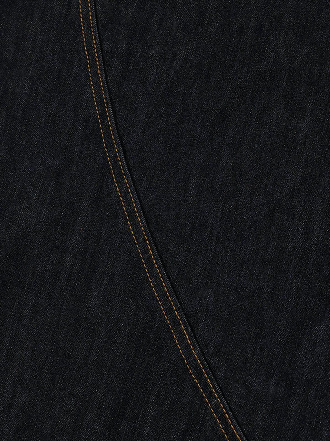 Intricate look at TALISHKO jeans showcasing the dark denim fabric with bold stitching detail.
