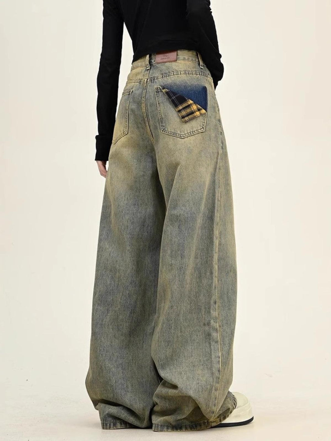 TALISHKO wide-leg jeans featuring a unique plaid pocket detail, styled with a casual black top.