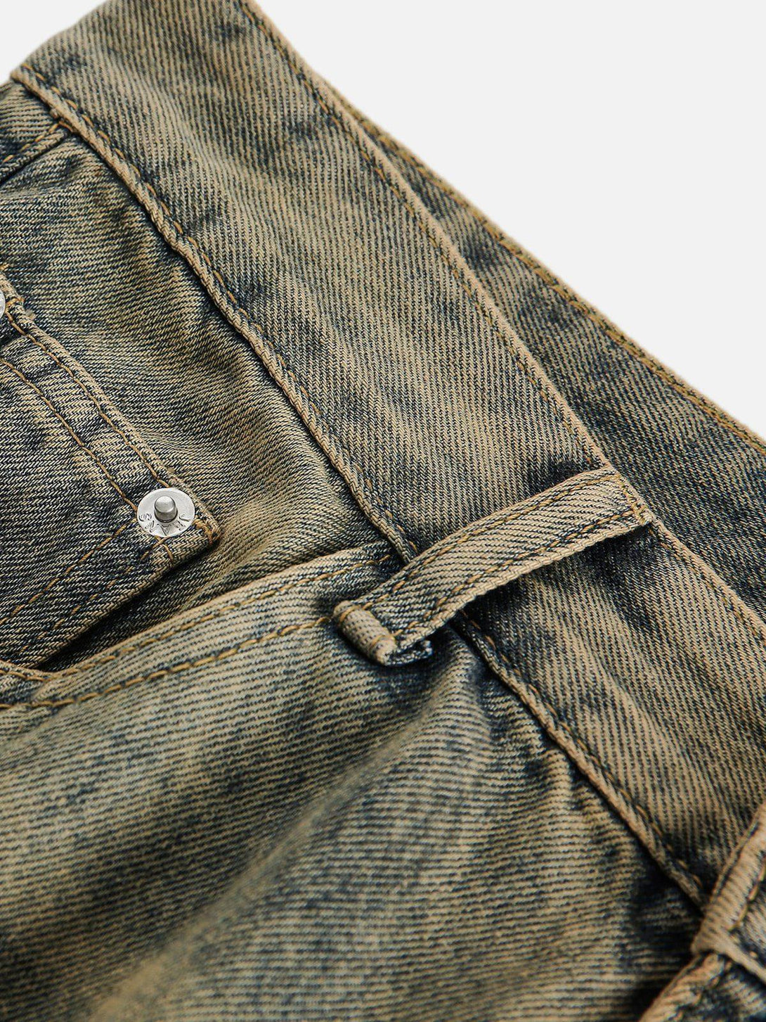 A detailed look at TALISHKO jeans showcasing the intricate stitching and washed denim texture.