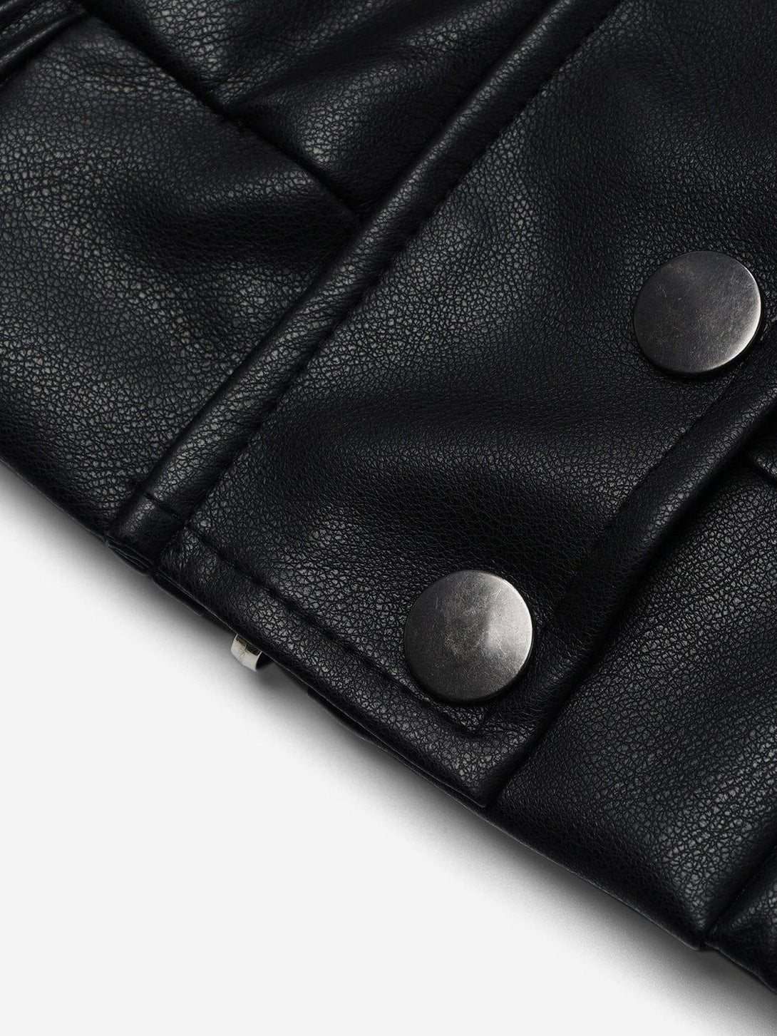 Close-up of the TALISHKO jacket's black leather texture, highlighting its metal button detail.
