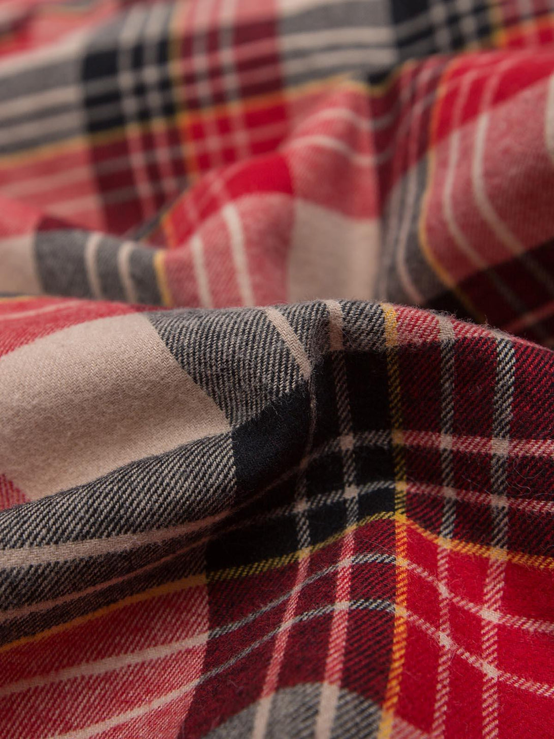 Zoomed-in texture of the plaid fabric by TALISHKO, highlighting cozy style details.