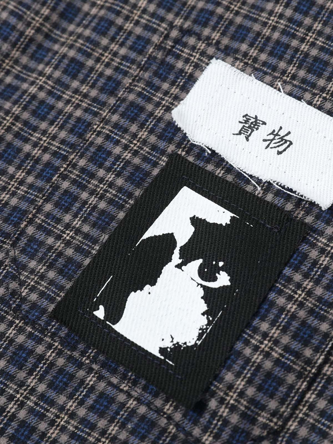 Intricate look at TALISHKO plaid shirt's patch and texture, showcasing unique style details.
