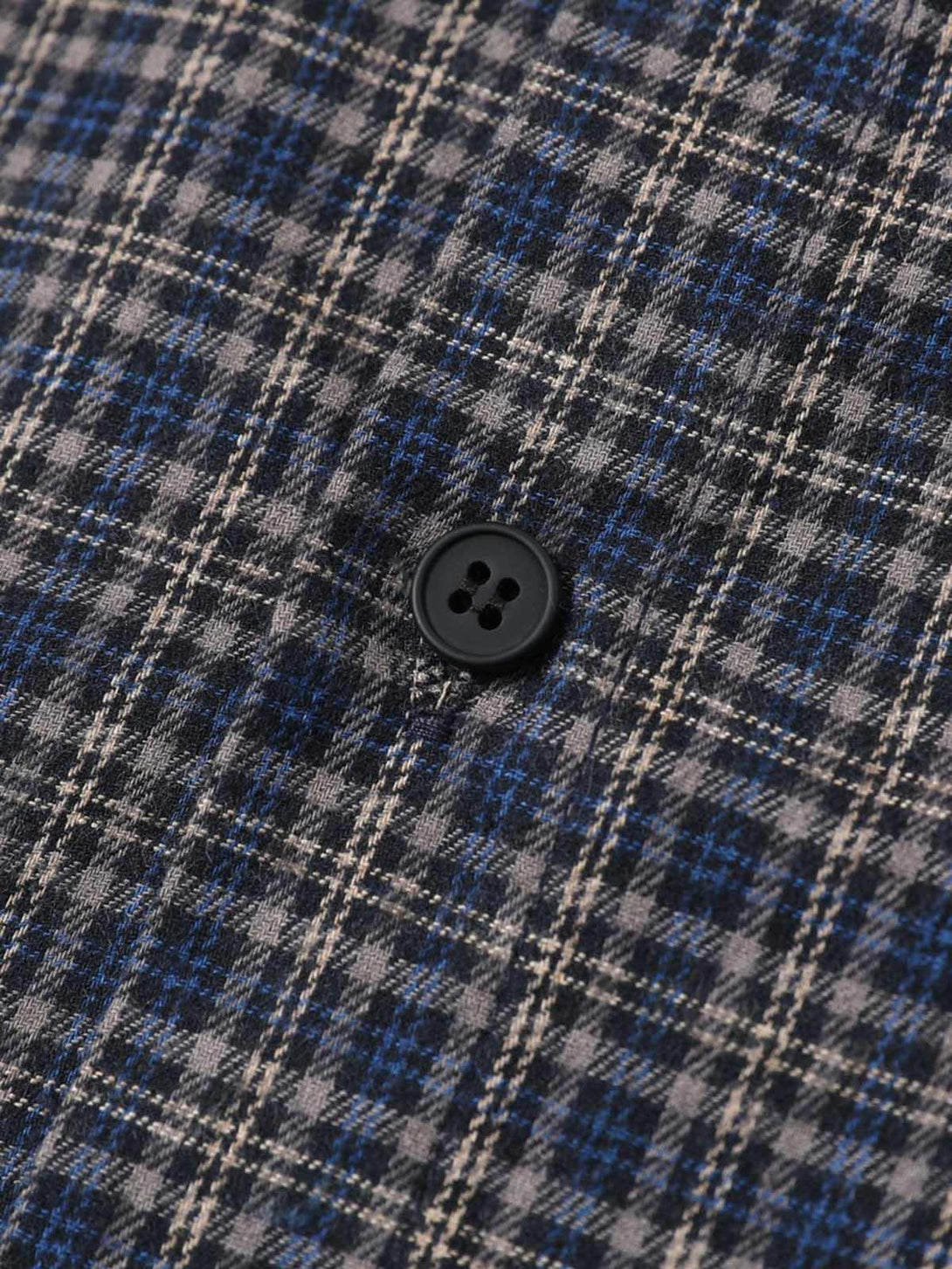 Intricate look at the plaid pattern and button detail on TALISHKO's short sleeve polo shirt.