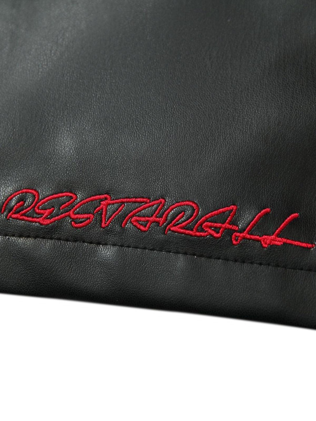 A close-up of TALISHKO's leather jacket with red embroidered detail on the black fabric.
