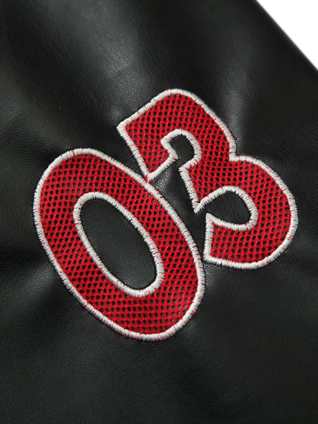 A close-up of TALISHKO's black leather jacket highlighting the red stitched "03" detail.