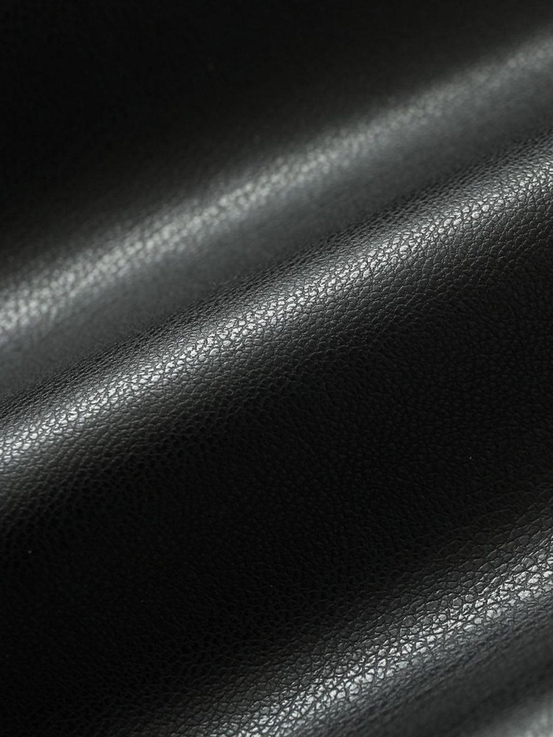 Zoomed-in texture of TALISHKO's leather jacket, highlighting its sleek and smooth surface.