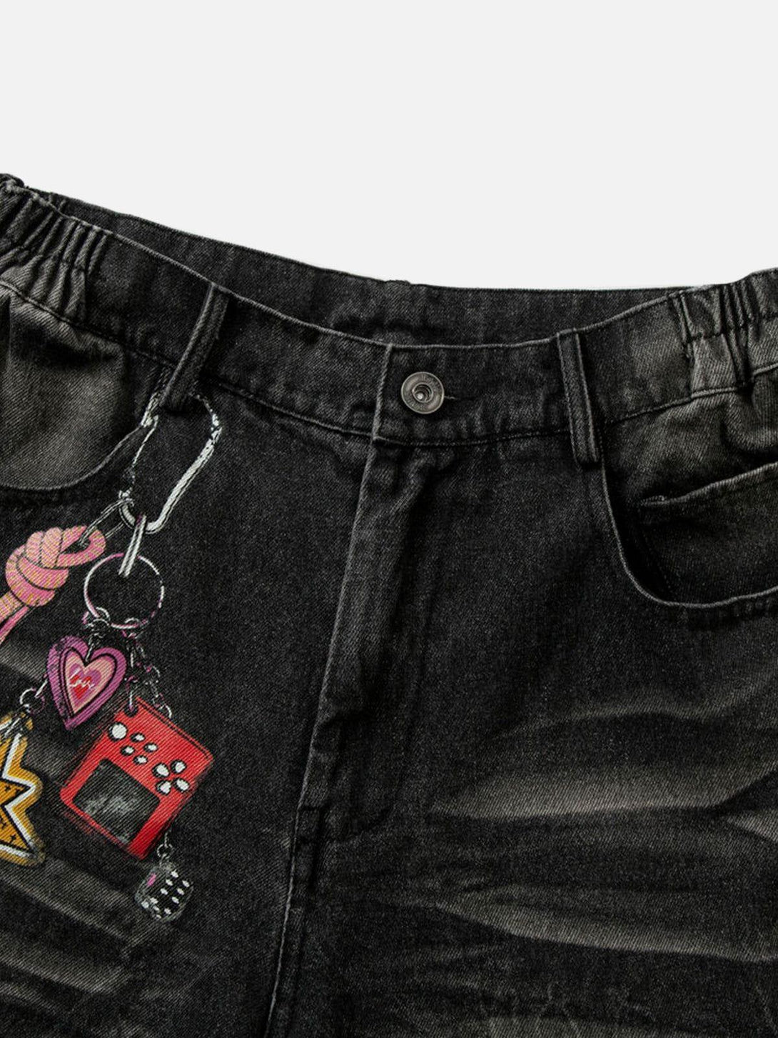 A detailed view of TALISHKO loose jeans with playful graphic prints and a washed finish.