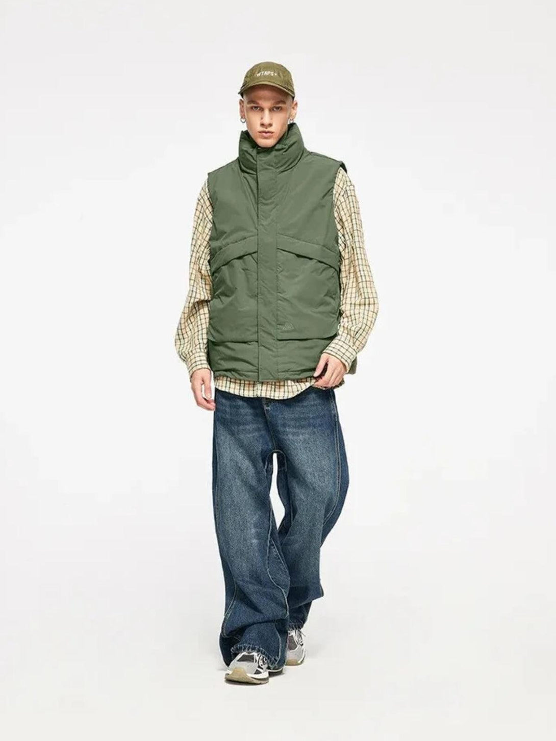 Model wearing a green windproof vest by TALISHKO, paired with relaxed jeans and sneakers.