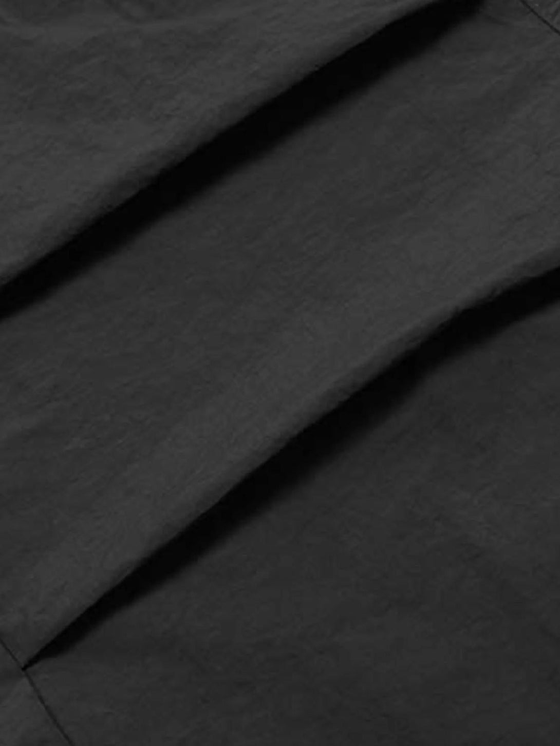 Intricate look at the pleated texture of TALISHKO cargo pants, emphasizing style details.