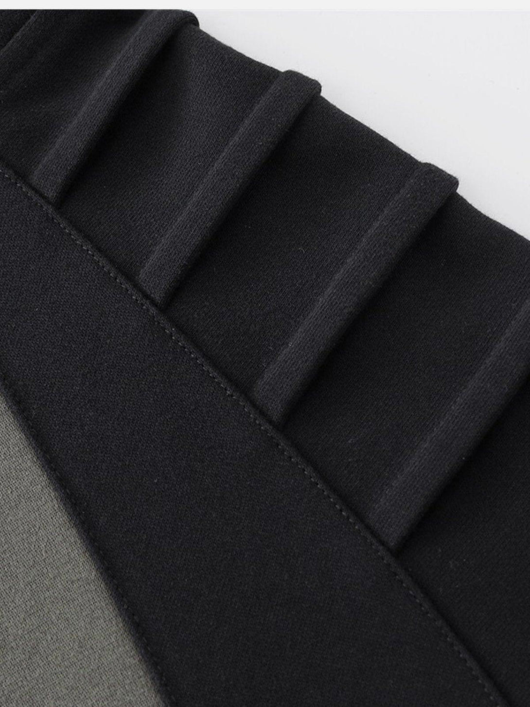 A detailed view of TALISHKO hoodie showcasing pleated design and material splicing.