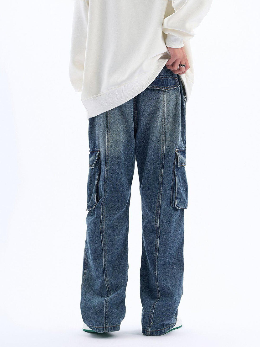 Back view of TALISHKO pleated multi-pocket jeans paired with a white sweatshirt, casual vibe.