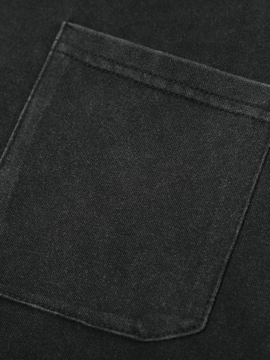 A close-up of TALISHKO's pocket on a black polo T-shirt, highlighting its sleek fabric texture.