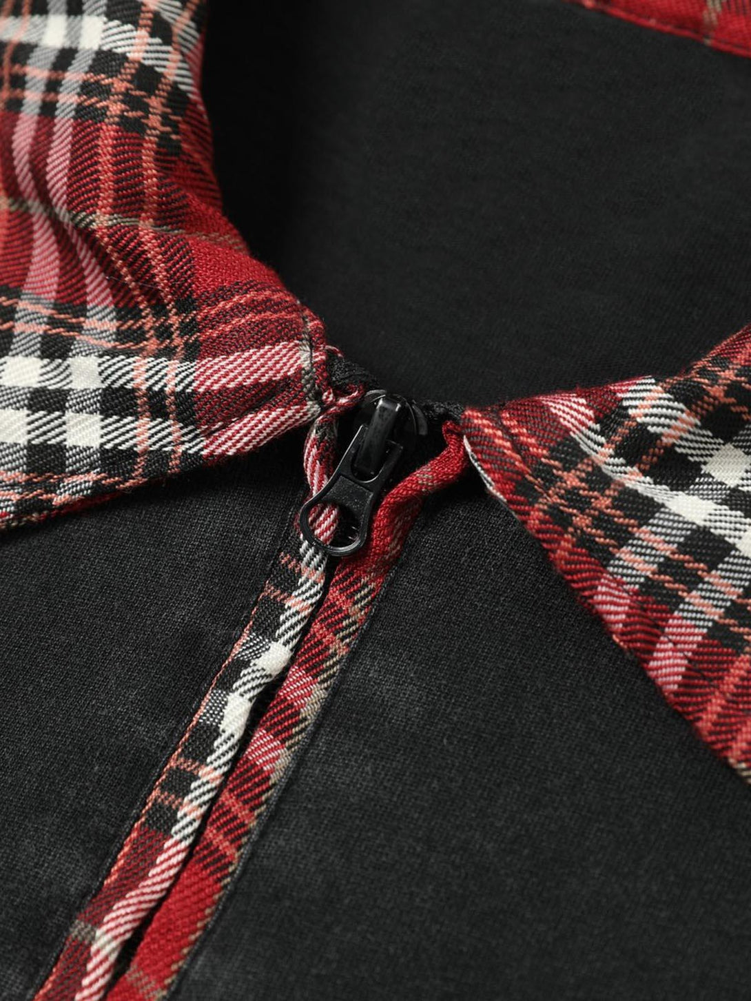 A close-up of TALISHKO polo T-shirt's zipper and plaid lapel, showcasing intricate design details.