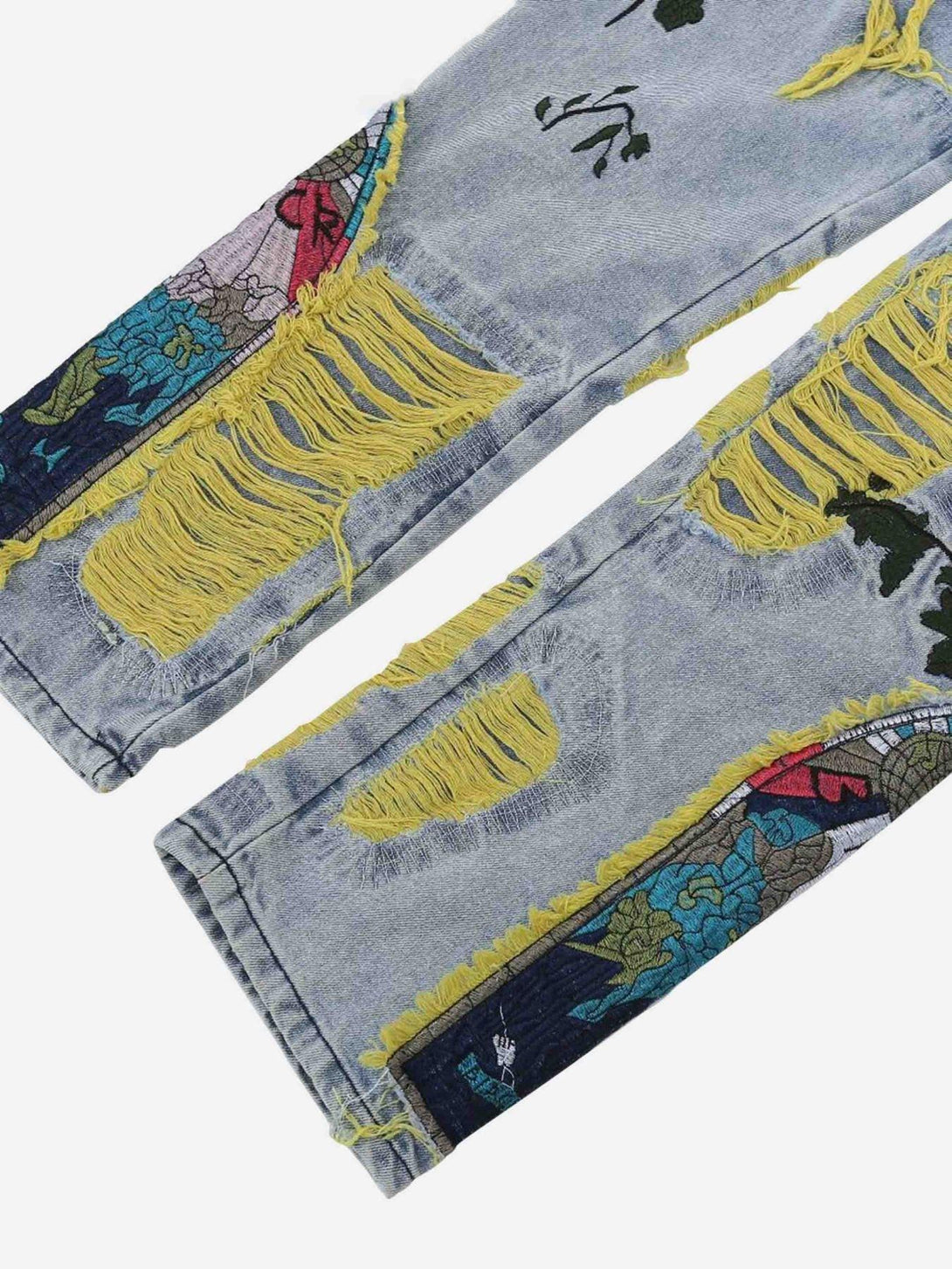Detailed look at TALISHKO jeans showcasing vibrant yellow distressing and floral embroidery.