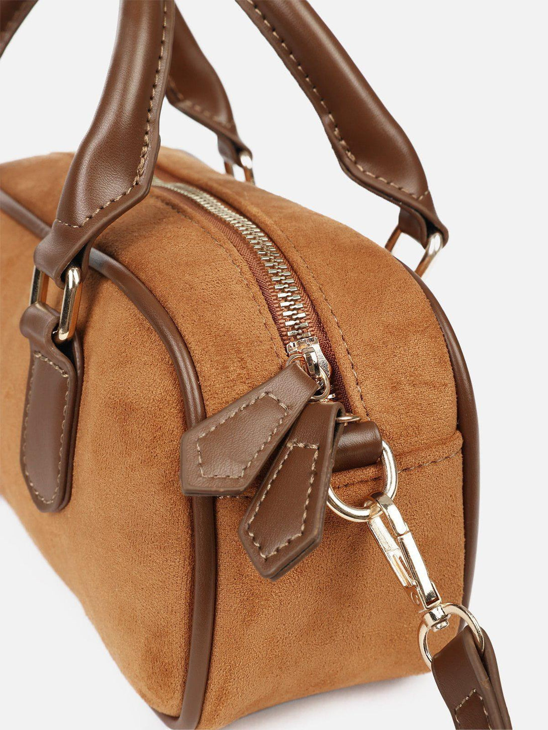 A close-up of the TALISHKO suede bag, highlighting the leather handles and zipper detail.
