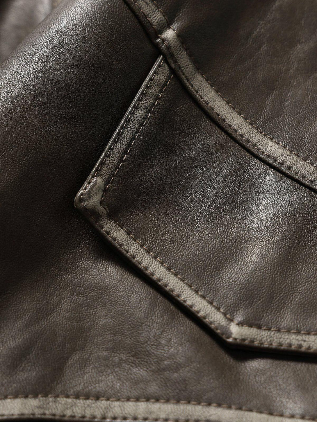 Detailed view of TALISHKO's faux leather jacket, highlighting patchwork and stitching design.