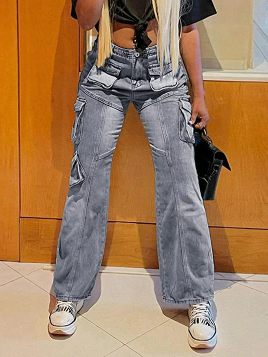 Model wearing TALISHKO's high-rise jeans with pocket patchwork, styled with casual sneakers.