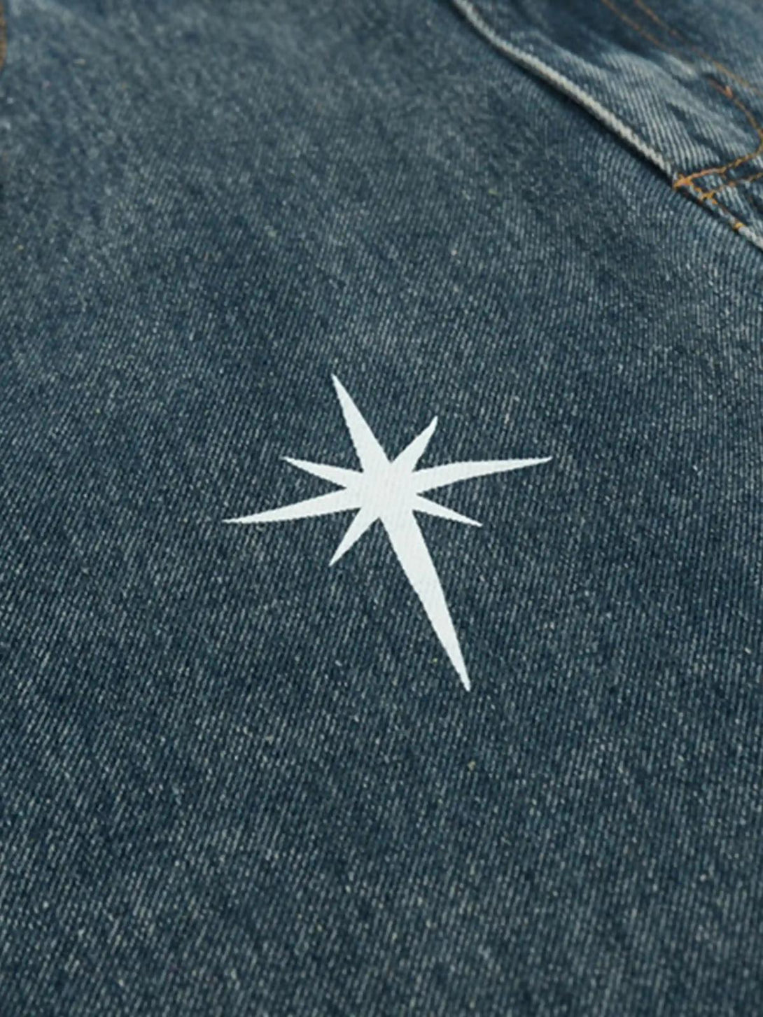 Intricate look at TALISHKO's washed denim with star motif, adding a stylish detail to the jeans.