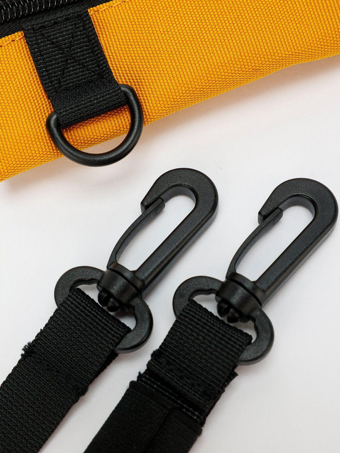 Intricate look at TALISHKO crossbody bag's black strap and hook details, enhancing functionality.