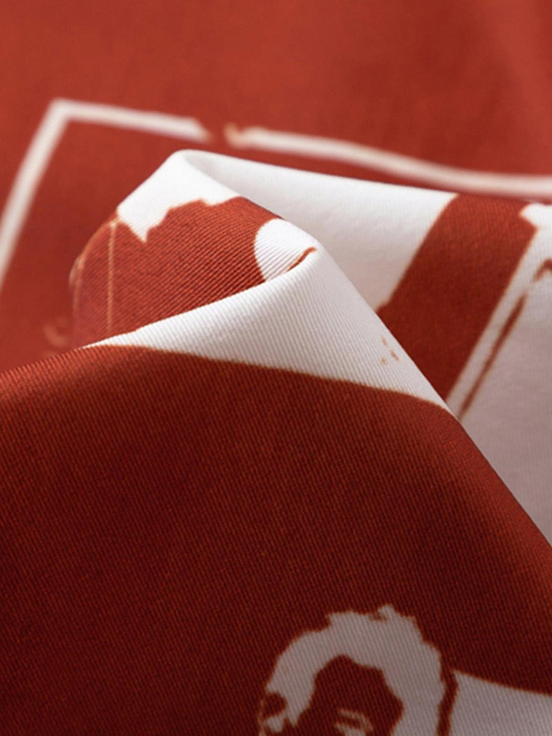 "Intricate look at the TALISHKO shirt's red fabric, showcasing detailed portrait patterns."