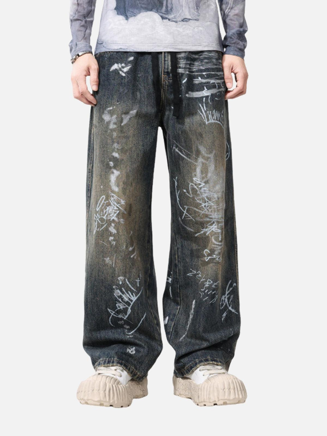 Model in TALISHKO hand-painted graffiti baggy jeans, showcasing artistic streetwear style.