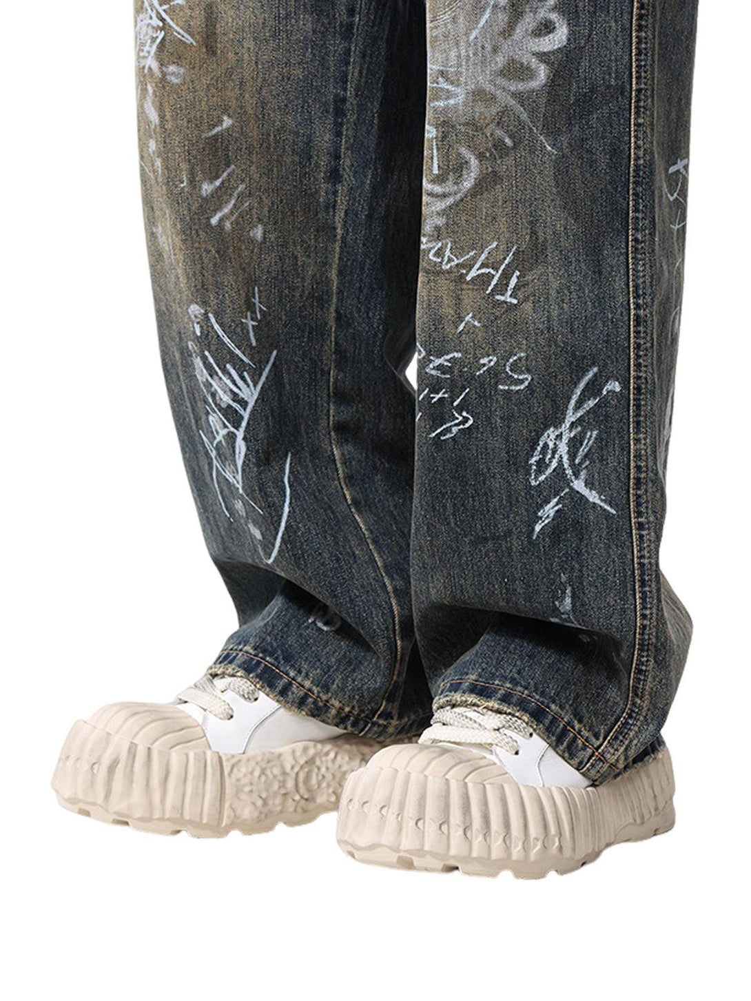 TALISHKO baggy jeans with hand-painted graffiti and chunky sneakers, highlighting streetwear flair.