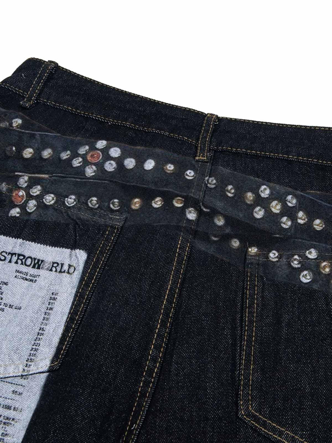 A detailed look at TALISHKO baggy jeans with unique print and stud embellishments on the back.