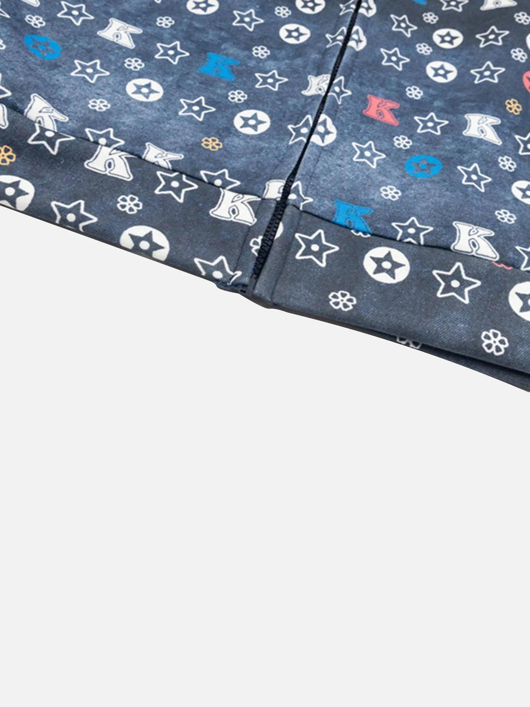 Intricate look at TALISHKO hoodie pattern with stars and letters on a dark gradient fabric.