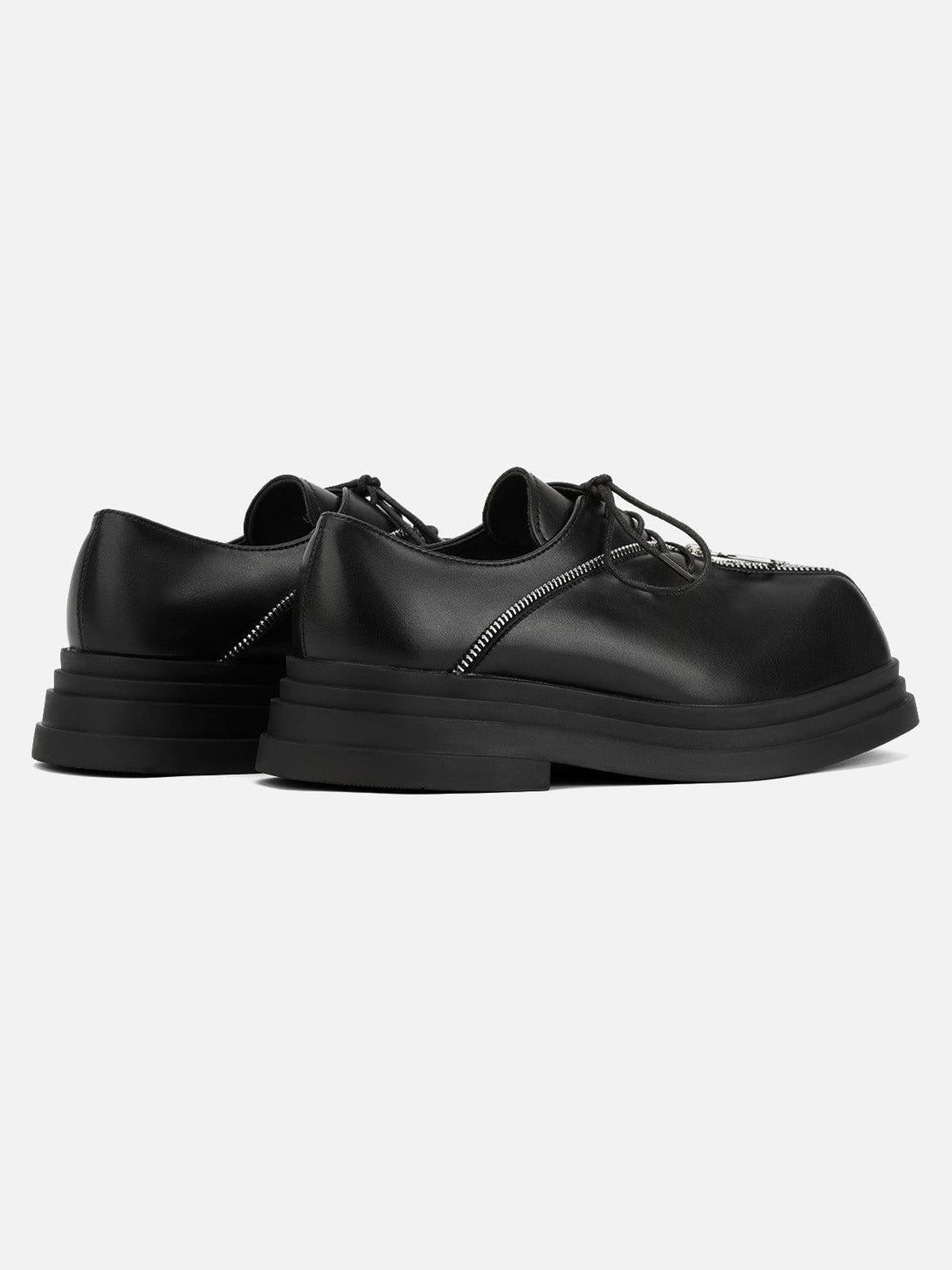 Rear angle of TALISHKO black leather shoes, highlighting unique zipper accents for a punk vibe.