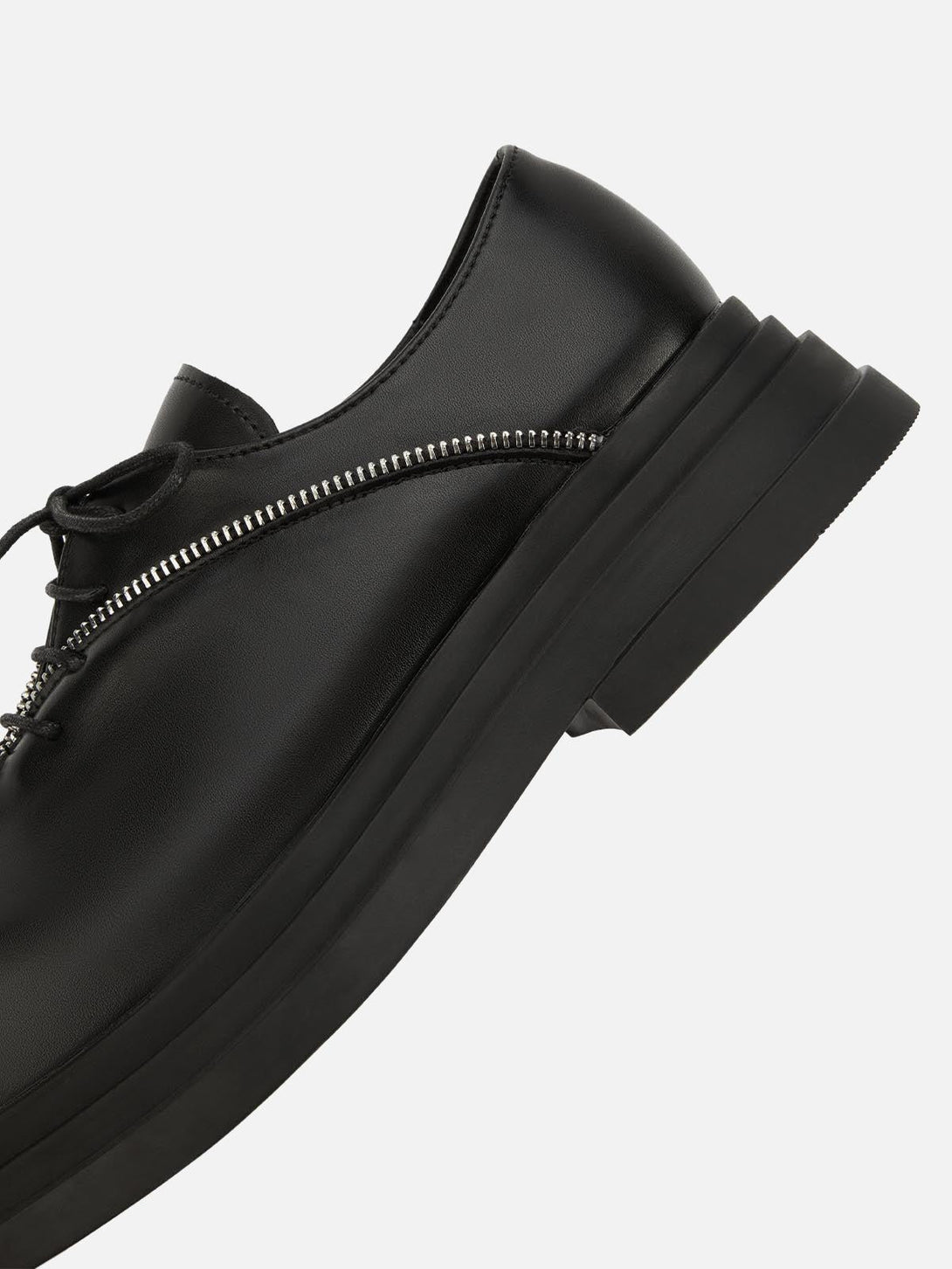 A close-up of TALISHKO leather shoes, featuring a prominent zipper for a punk-inspired style.