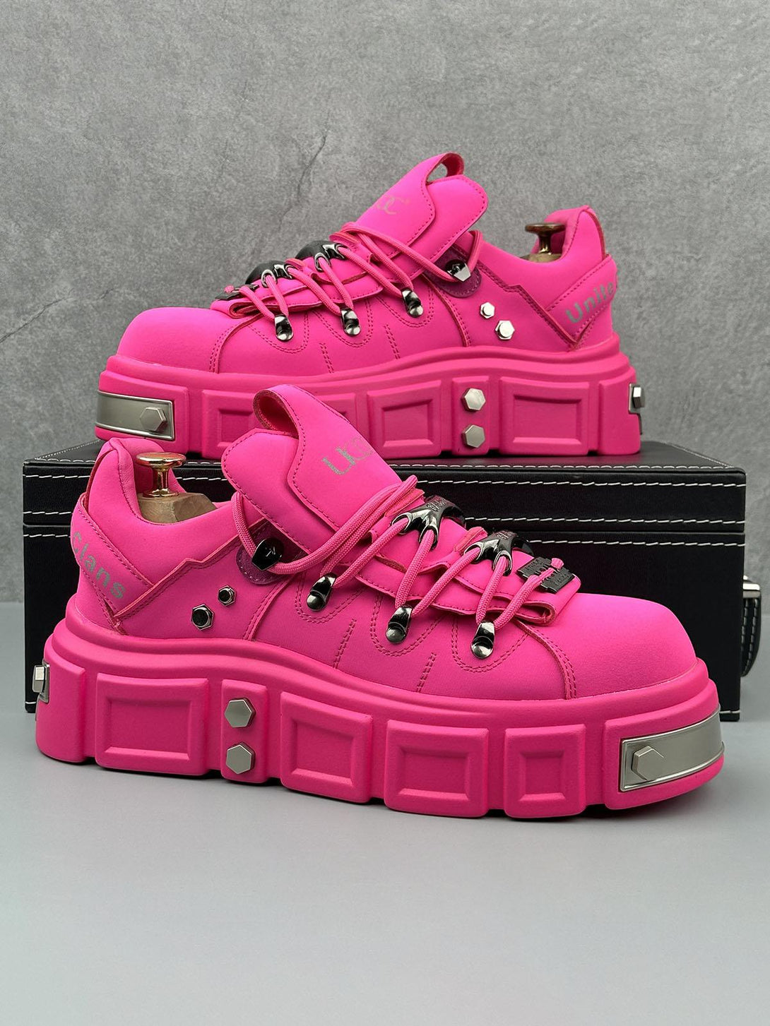 TALISHKO's vibrant pink derby shoes with chunky design and rivet accents, offering edgy flair.
