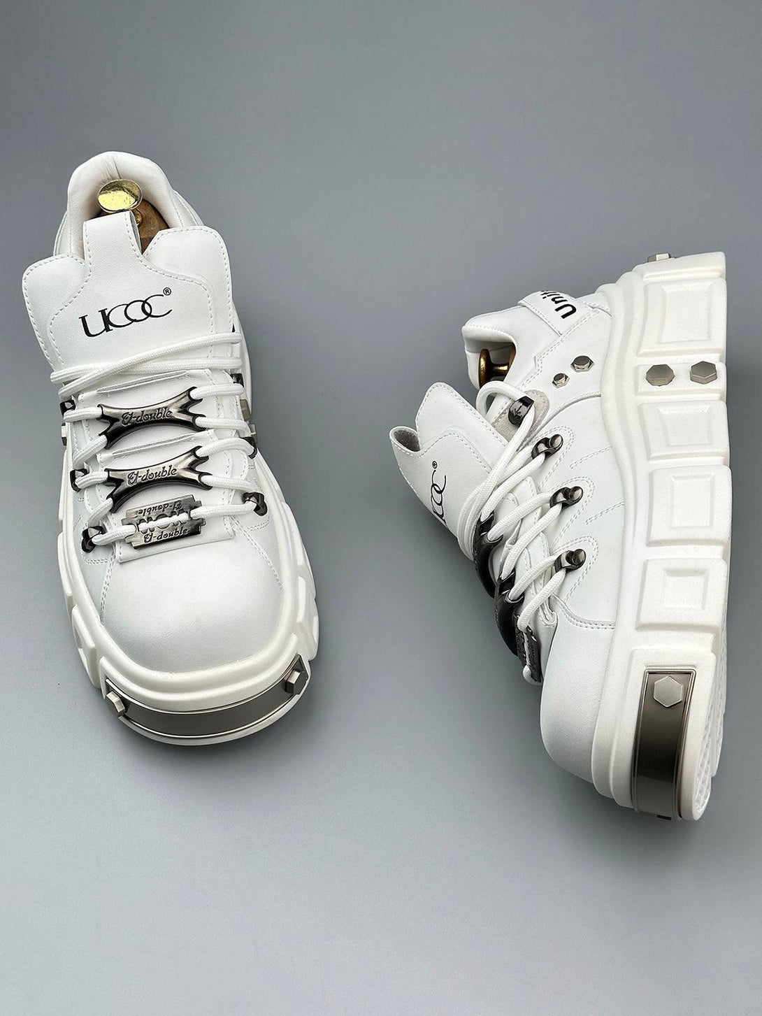 TALISHKO white derby shoes with chunky soles and rivet details, ideal for a punk-inspired look.