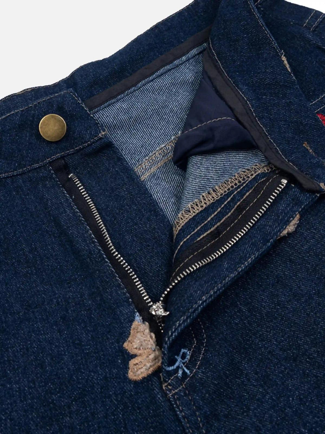 Focusing on the zipper detail of TALISHKO jeans, highlighting intricate denim craftsmanship.