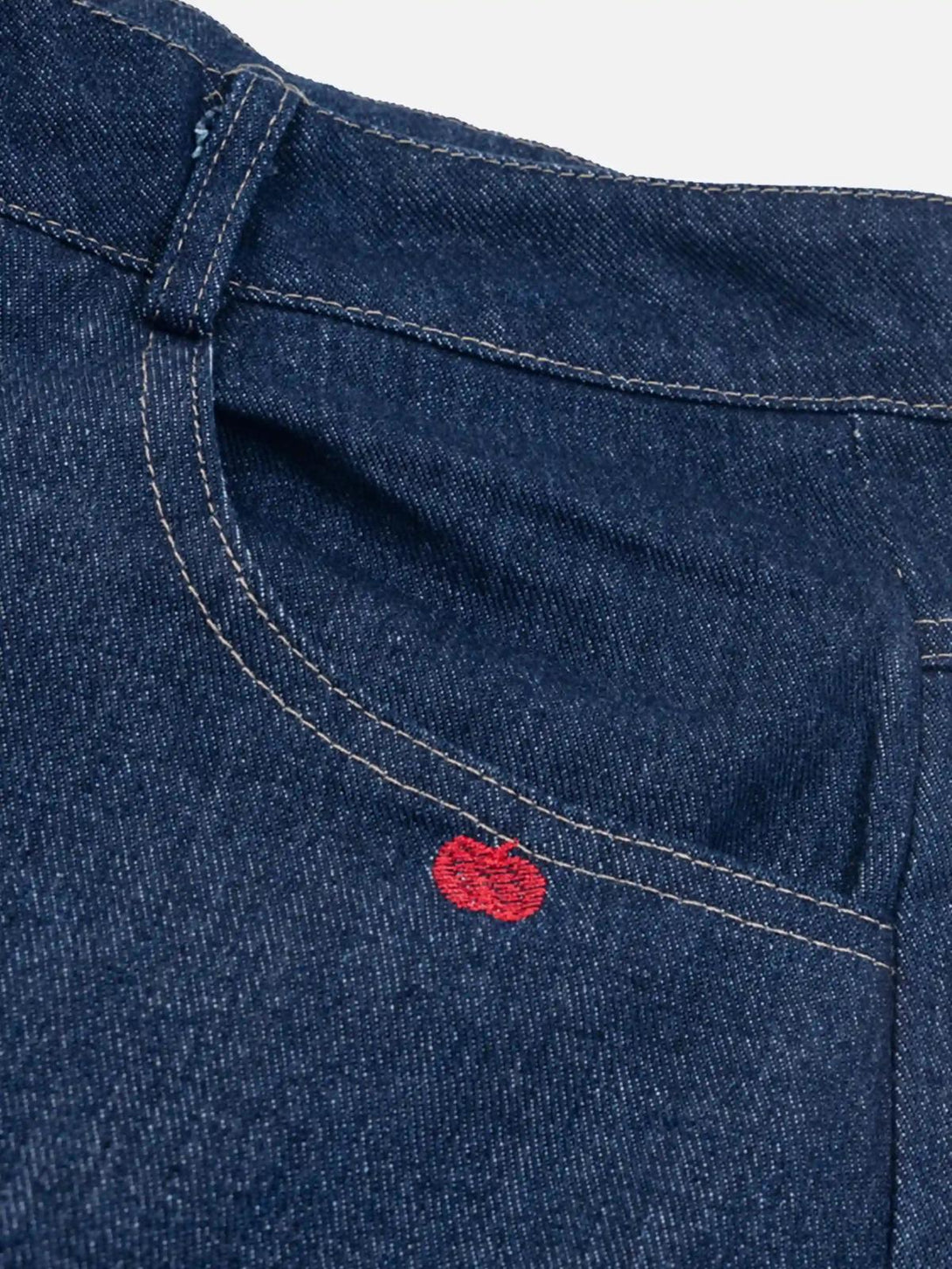 Detailed fabric and stitching on TALISHKO jeans, featuring a cute red apple embroidery.