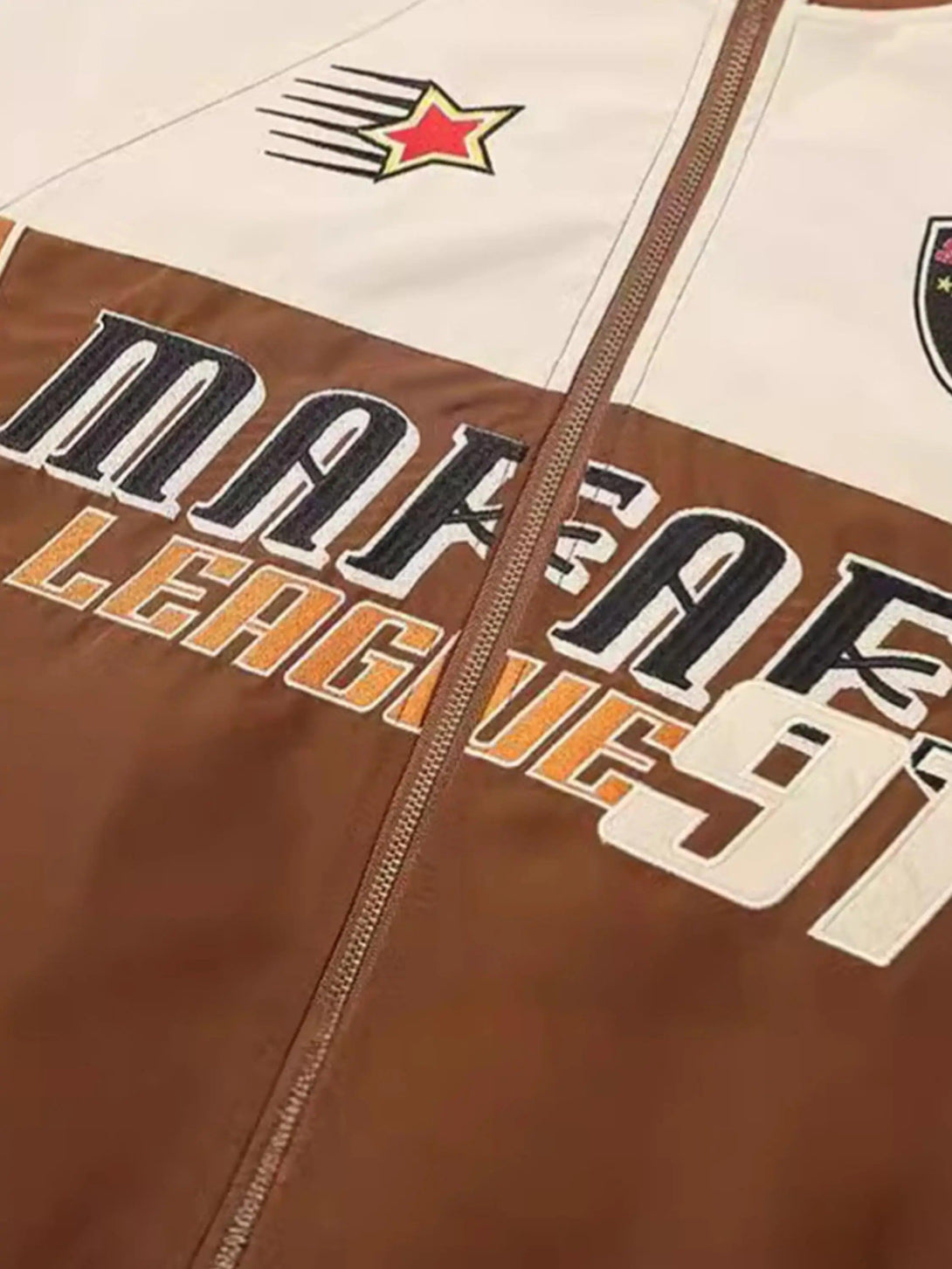 Focusing on the front embroidery and patchwork of TALISHKO's racing jacket, highlighting bold text.