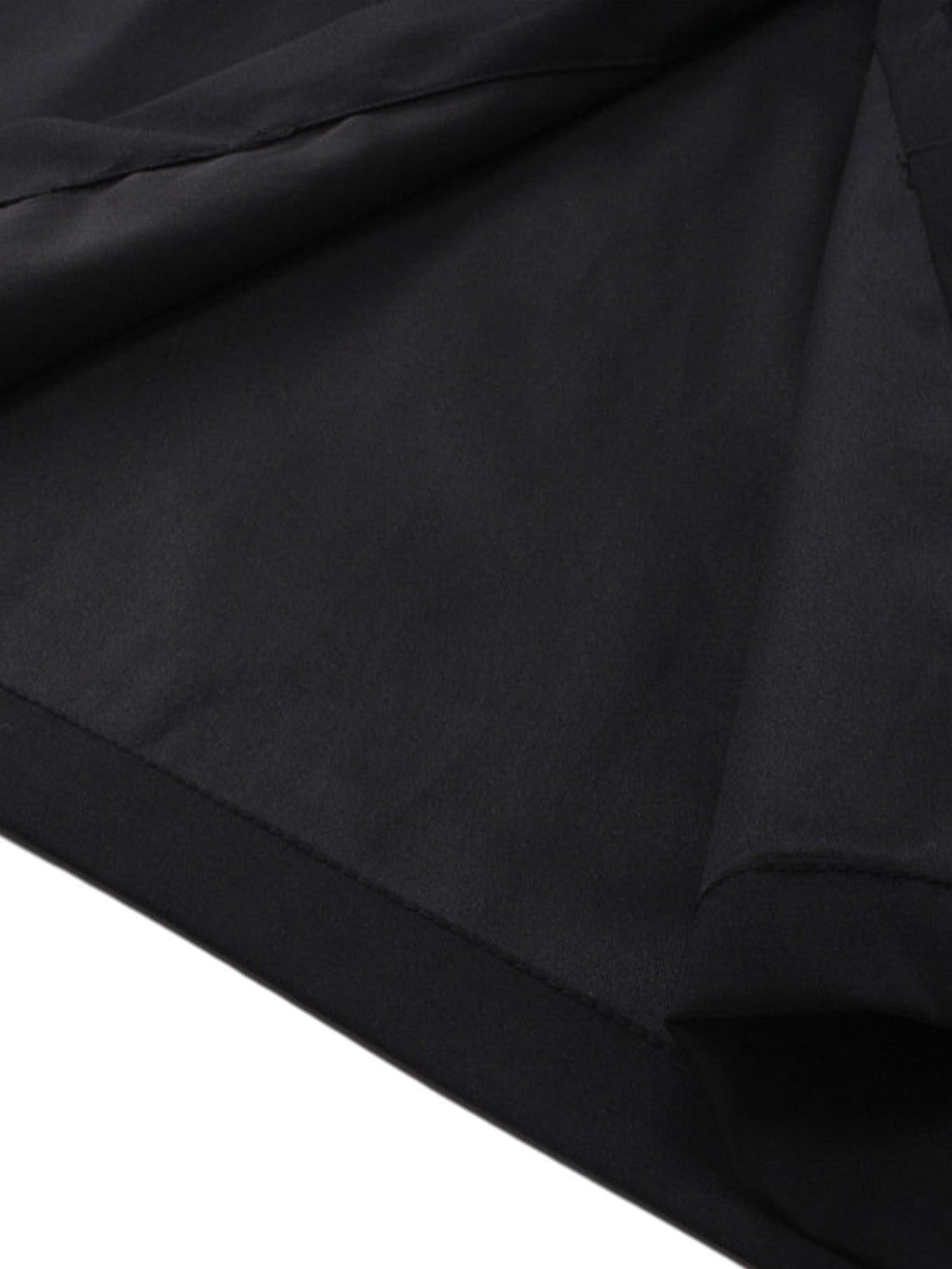 A detailed look at the hem of a black racing-style shirt by TALISHKO, showcasing sleek fabric.