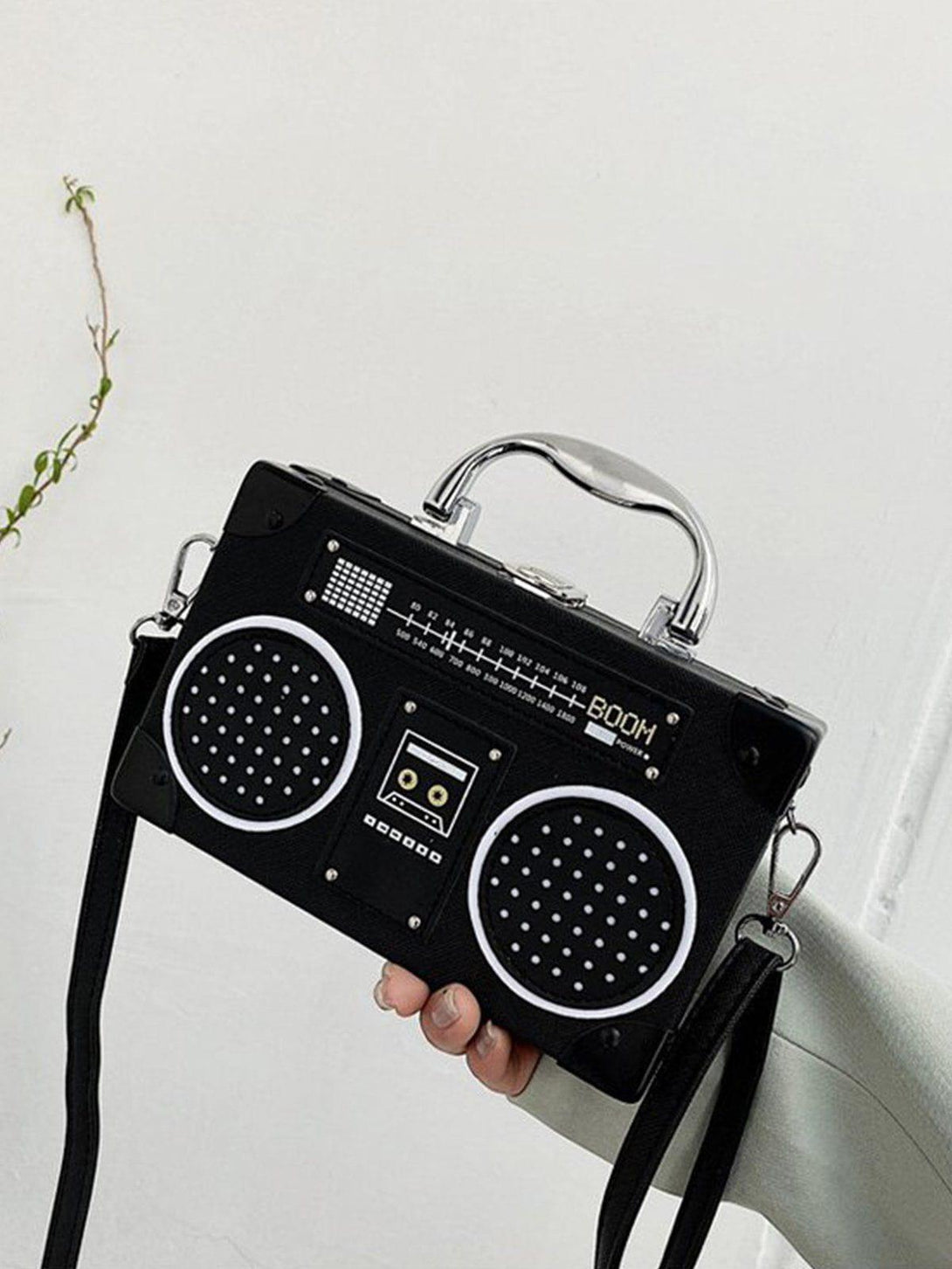 A detailed view of a black retro radio style crossbody bag by TALISHKO, adding a playful touch.