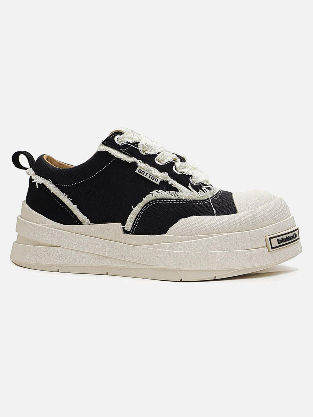 Side view of TALISHKO raggedy round toe sneakers with a black and cream design, featuring textured details.