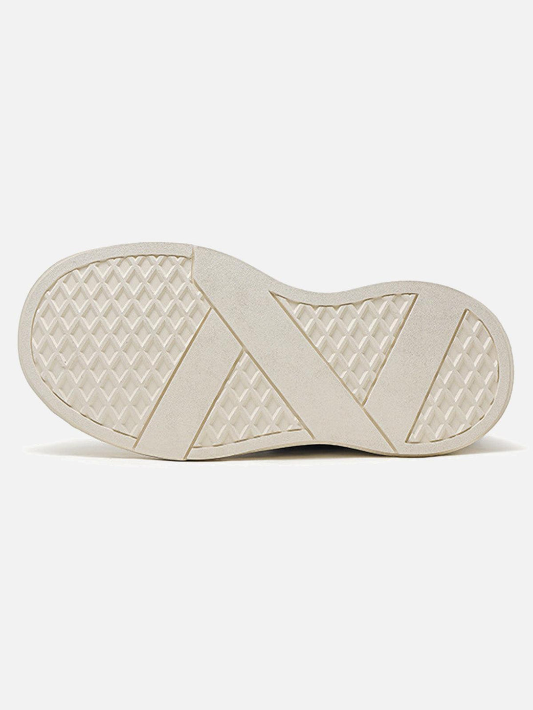 A detailed view of the cream sole pattern on TALISHKO raggedy round toe sneakers.