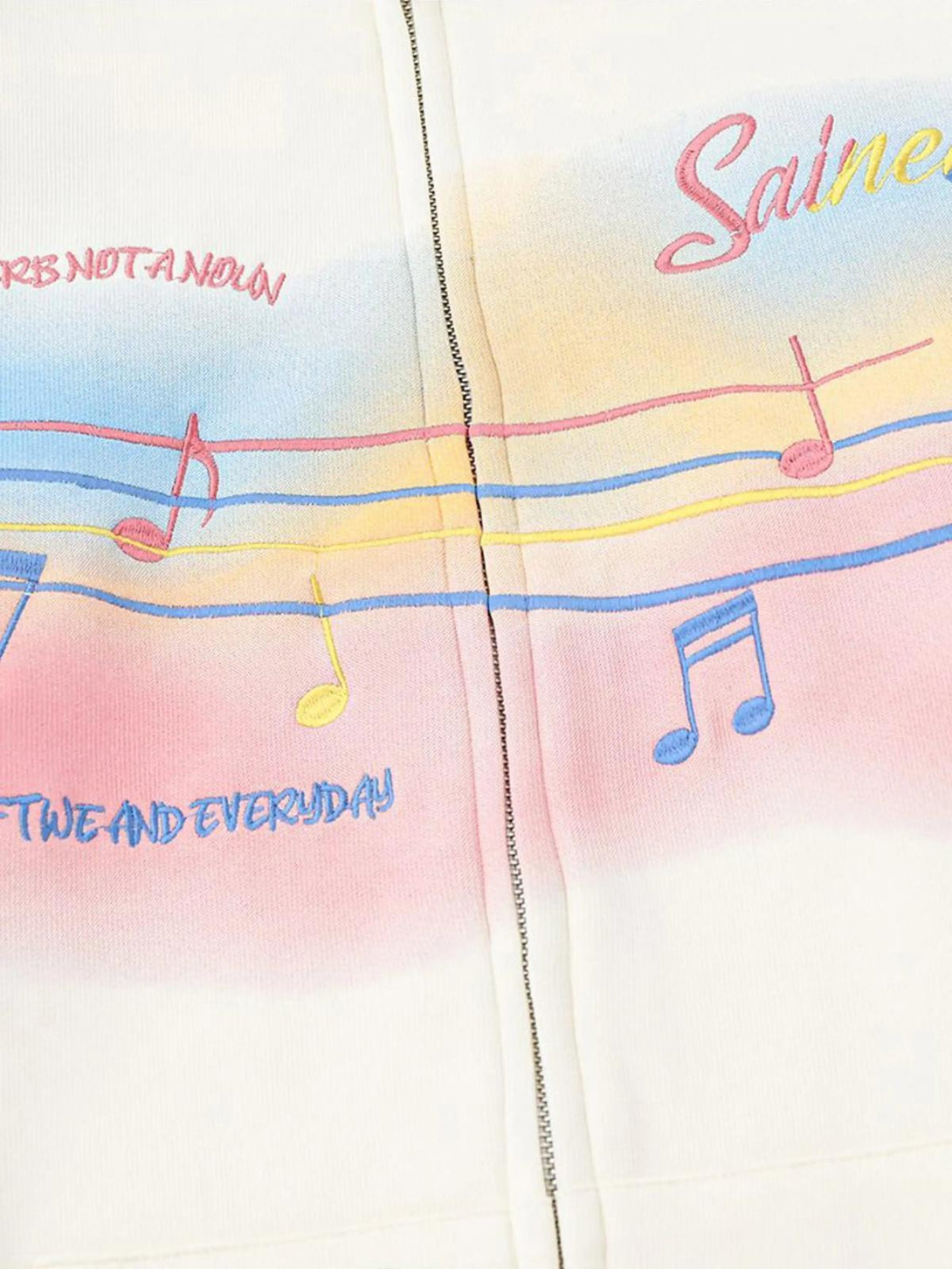 Detailed view of TALISHKO hoodie showcasing rainbow musical notes and vibrant embroidery.