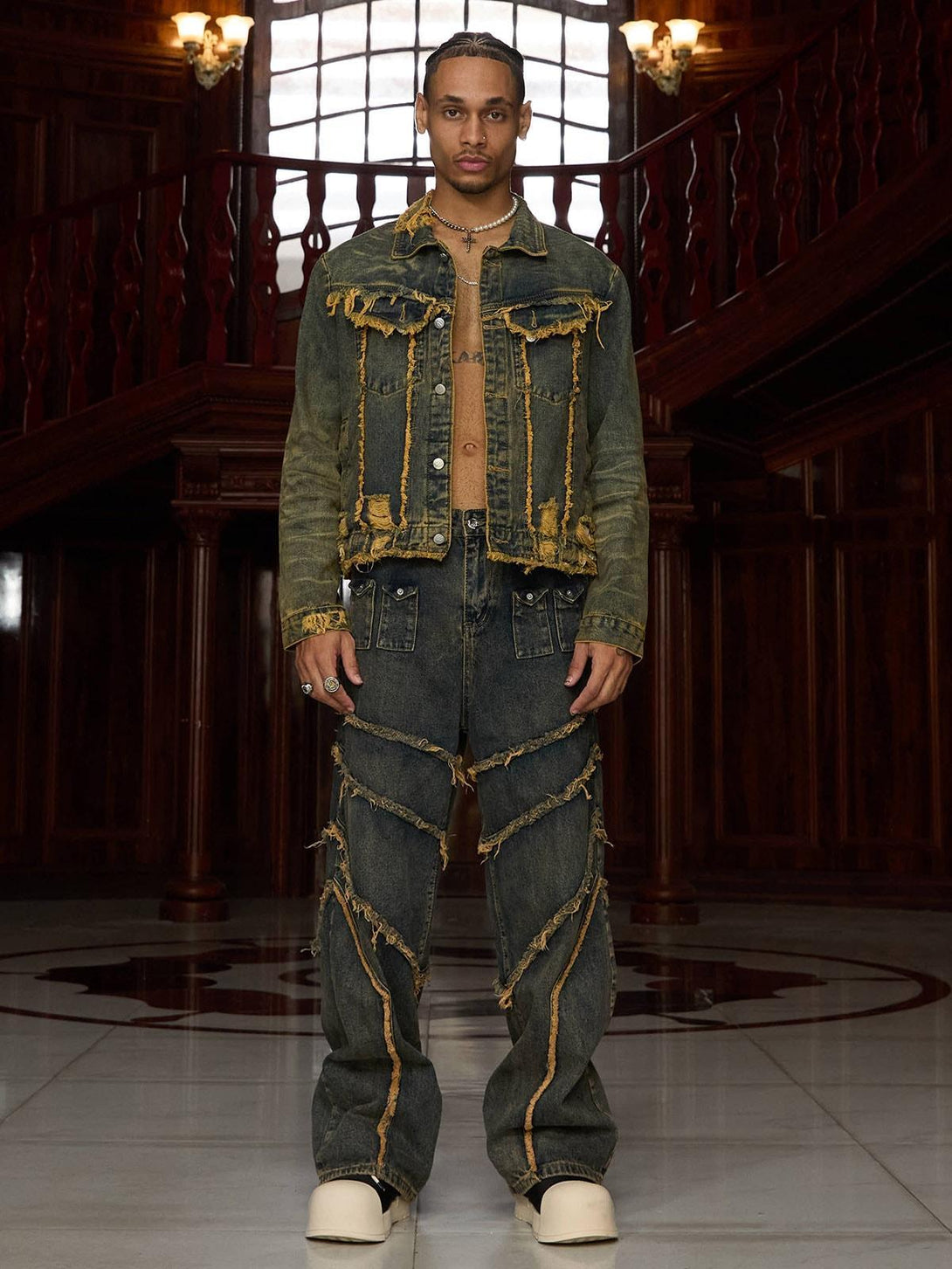 Model wearing TALISHKO's distressed denim jacket with raw edges, paired with matching jeans.